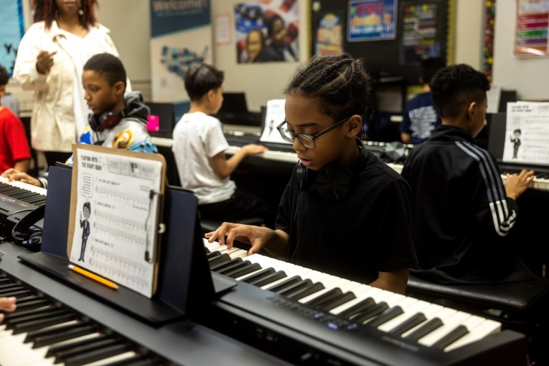 elementary students playing piano