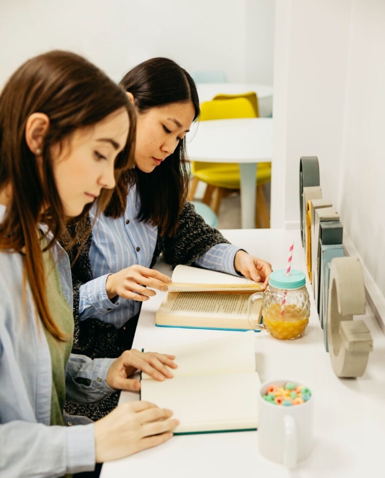 high school students reading book in cafe-style library