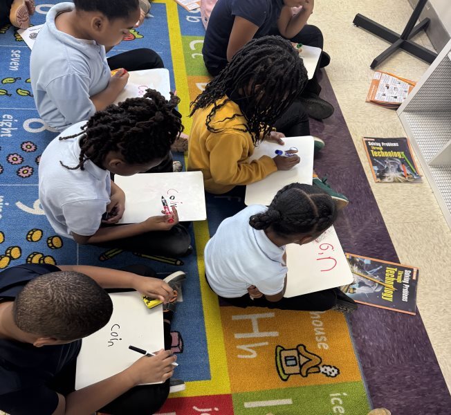 elementary students working on classroom carpet