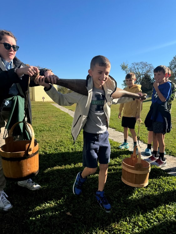 elementary student carrying buckets