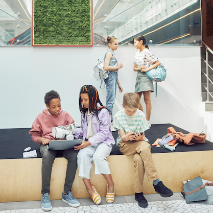 young students in communal space with green wall