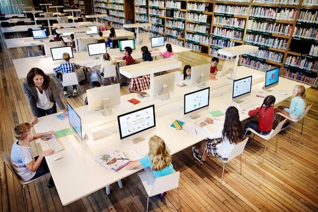 elementary students in multimedia library space