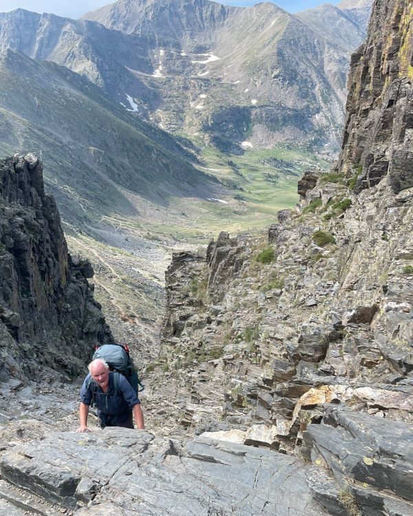 hiker climbing steep mountain pass