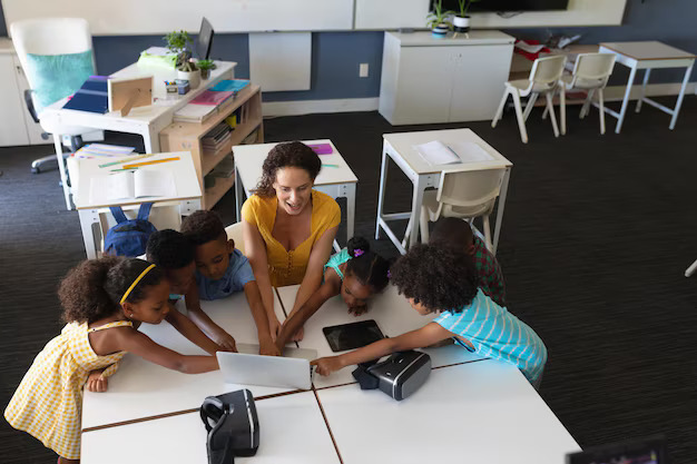elementary teacher with small group table and a laptop computer