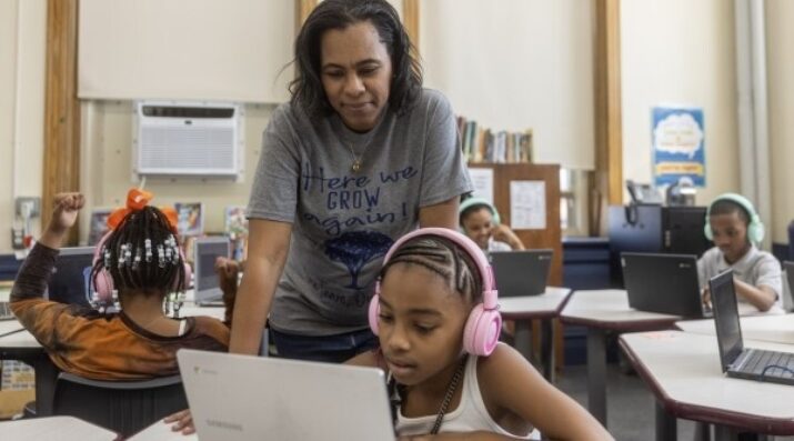 middle school student on computer with teacher support