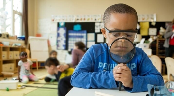 kindergarten student with magnifying glass