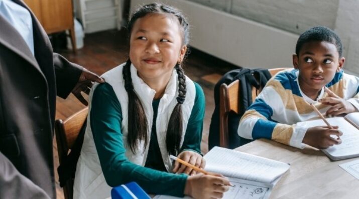 students with math worksheets at classroom table