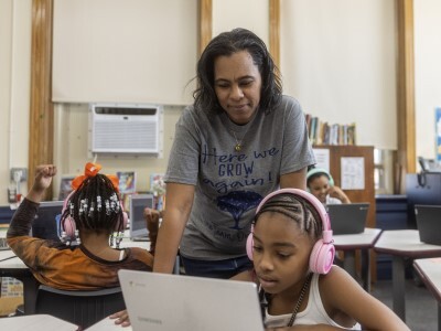 middle school student on computer with teacher support