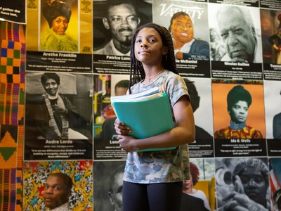 Student with mural of Black leaders