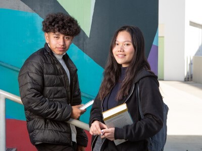 high school students outside holding books