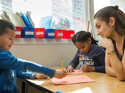 Teacher working with students on their learner profiles