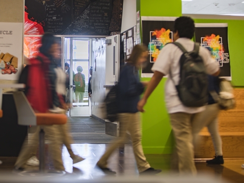 students walking across bright hallway