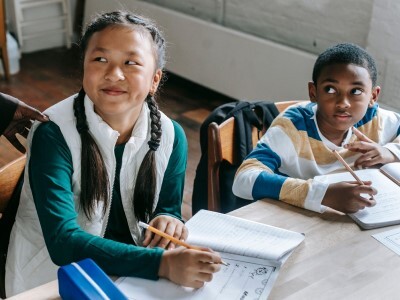 students with math worksheets at classroom table